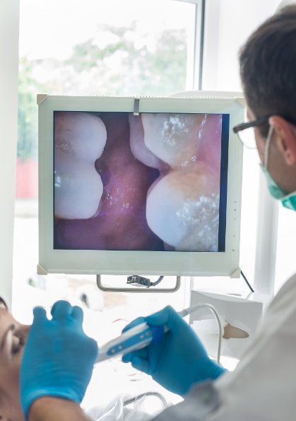 Dentist looking at close up photos of a patient's teeth during dental exam