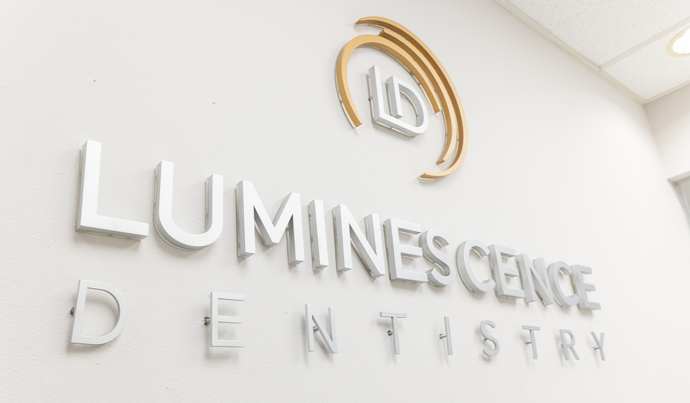 Luminescence Dentistry sign on white wall of Dallas dental office
