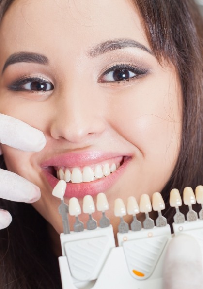 Young woman grinning while trying on dental veneers from her cosmetic dentist in Dallas