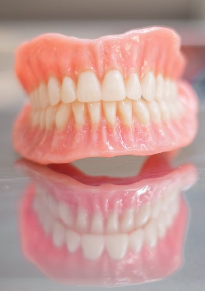 Set of full dentures resting on gray surface