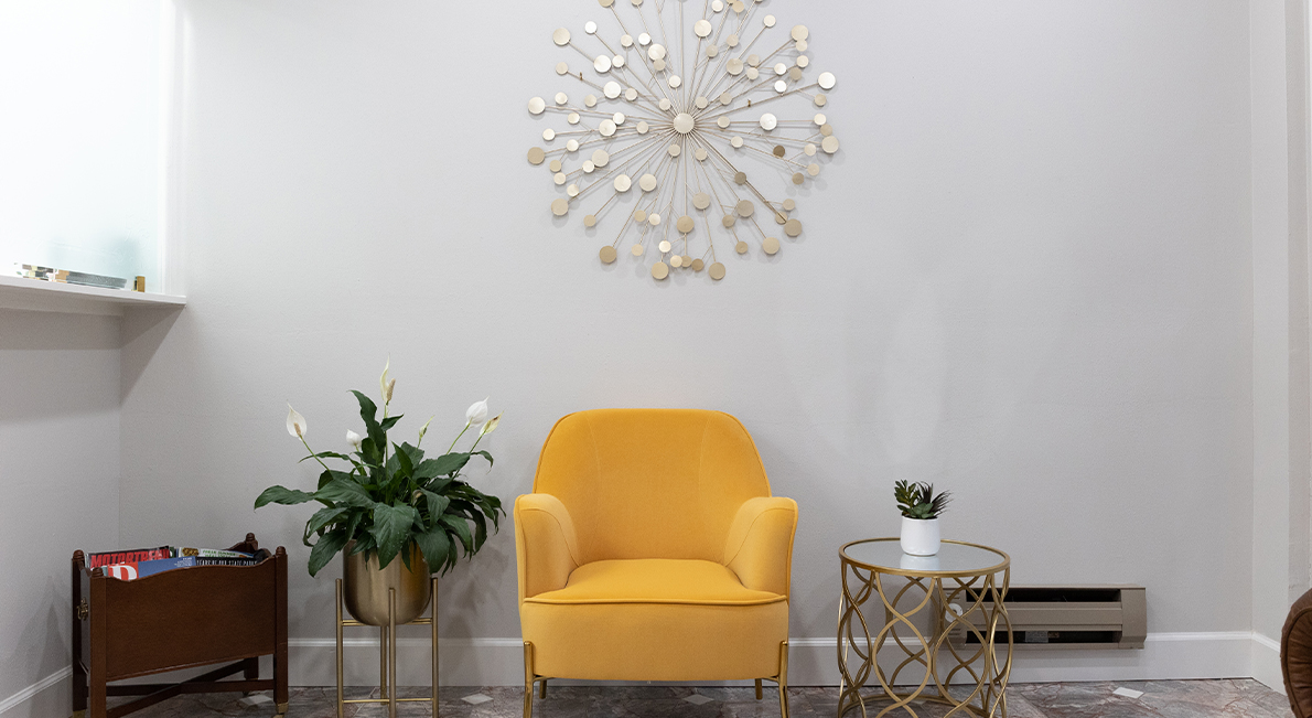 Yellow armchair in front of white wall
