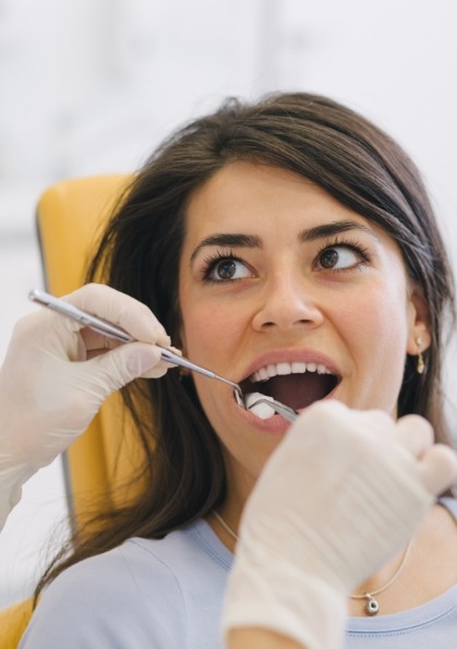 Woman having her mouth examined by dentist during preventive dentistry visit